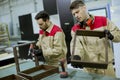 Two young workers assembling furniture in the factory Royalty Free Stock Photo