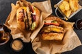 Two yummy grilled chicken burgers in a craft box, fries and cola on a dark background, top view. Hamburger and French fries.