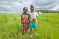 Two Zulu black boys in rural area of Zululand with village in background, South Africa