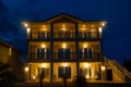 twostory house with balcony lights and illuminated entrance