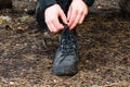 Tying bootlaces of military styled combat boots in a forest Royalty Free Stock Photo