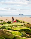 Two boys holding buckets playing at King Edward`s Bay beach on a