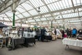 Tynemouth Metro Station Weekend Flea Market. Various stalls with people browsing under Victorian iron work and glass roof