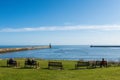 Tynemouth Harbour and Tyne River estuary with people sitting looking out to sea