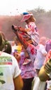 Young girl sits on mothers shoulders at the end of a Charity Colour Paint Run.