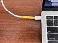 Type-c cable wrapped with yellow electrical tape plugged into a port, highlighting a makeshift repair or temporary fix Royalty Free Stock Photo