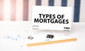 TYPE OF MORTGAGES sign on paper on white desk with office tools. Blue and white background Royalty Free Stock Photo
