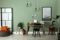 Typewriter, stack of papers and mood board on wooden table near pale wall. Writer`s workplace