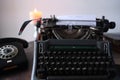 Typewriter on table, words fake news are printed on paper in large size, candle is burning, retro style, concept of information