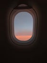 Typical airplane window view with pastel sky sunset and dark background wallpaper dreaming atmosphere concept
