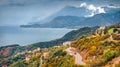 Typical Albanian landscape on the Adriatic shore with asphalt road and misty mountains