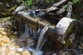 typical alpine wooden water fountain overflowing with fresh water