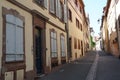 Typical Alsatian architecture in a narrow street in Colmar, France paved with cobblestones. The houses are properly maintained and Royalty Free Stock Photo