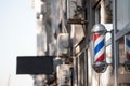 Typical American barbers pole seen in front of a barber shop.