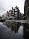 Typical Amsterdam architecture street houses reflection in rain water puddle city center Holland Netherlands Royalty Free Stock Photo