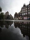 Typical Amsterdam architecture street houses reflection in rain water puddle city center Holland Netherlands