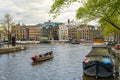 Typical Amsterdam canal with houses and floating boats in springtime, Holland Netherlands Europe