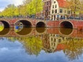 Typical Amsterdam canals with bridges and colorful boat reflection, Netherlands, Europe