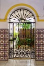 Typical Andalusian patio with its green plants in pots, metal grilled doors and colorful tiles, Ecija, Sevilla.