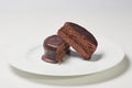 Typical Argentine Alfajor of dark chocolate cut in the middle where you can see the interior of chocolate and the filling of dulce Royalty Free Stock Photo