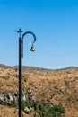 Armenia, Amberd, September 2022. Bronze bell on a pillar with a cross.