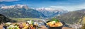 Typical Austrian food with panorama of Tauer Alps with Kitzsteinhorn peak over Zell am see town in Austrian Alps, Salcburgerland