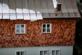 Typical Austrian house, home half paneled in wood, white wood window frames, cloudy and gloomy winter day, snow on the roof in the Royalty Free Stock Photo