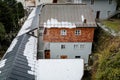 Typical Austrian house, home half paneled in wood, white wood window frames, cloudy and gloomy winter day, snow on the roof in the Royalty Free Stock Photo