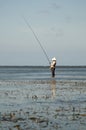 Typical Balinese fisherman standing in shallow water