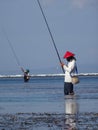 Typical Balinese fishermen standing in shallow water