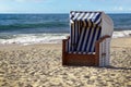 Typical beach basket chair in sand on blue sea on a sunny vacation day, copy space