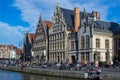 Typical belgian houses through the most famous canal in Ghent, Belgium, with river Lys Leie river and people sitting on the