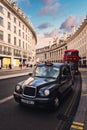Typical black cab and red double decker bus in London at sunset Royalty Free Stock Photo