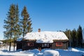 Typical black Norwegian cabin with fir trees