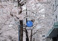 A typical blue-coloured street sign in Tokyo City`s showing an adult and a child walking while holding hands, and a bicycle right