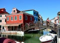 Typical brightly colorful houses and narrow channels with tourists in Burano, Venice, Italy
