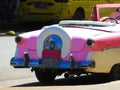 Typical car from Havana, Cuba. Photo from the street. Rear view pink car.