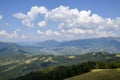 Typical Carpathian village in a valley, forest and mountains under blue sky with white clouds. Carpathians, Ukraine Royalty Free Stock Photo