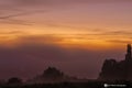 A typical colorful Autumn sunrise in Maastricht with the landscape covered with a layer of fog, leaving only silhouettes visible i Royalty Free Stock Photo