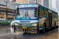 Typical colorful blue decorated bus in heavy rain Bangkok Thailand