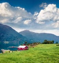 Typical countryside Norwegian landscape with red painted wall house. Picturesque summer morning in Norway, Europe. Beauty of Royalty Free Stock Photo