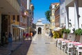 Typical croatian street with colorful buildings on both sides and the Sea Gate, one of the stone gates of Zadar, Croatia, at the