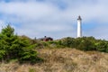 Typical Danish coastal landscape with red house and Lyngvid Fyr lighthouse in the sand dunes Royalty Free Stock Photo