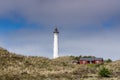 Typical Danish coastal landscape with red house and Lyngvid Fyr lighthouse in the sand dunes Royalty Free Stock Photo