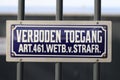 Typical dutch blue and white sign with text `verboden toegang` which means no admittance with law article under it