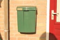 A green mailbox closeup at a house in holland in the sunshine