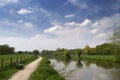 Typical Dutch landscape with river Kromme Rijn, walkway, clouds and trees Royalty Free Stock Photo
