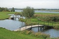 Typical dutch polder with grass, water and small bridges in the polder Hoekse Waard