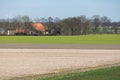 Typical Dutch polder landscape with farmhouse and bare fields Royalty Free Stock Photo