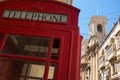 Typical English phone booth with a church in Valletta, Malta in the background